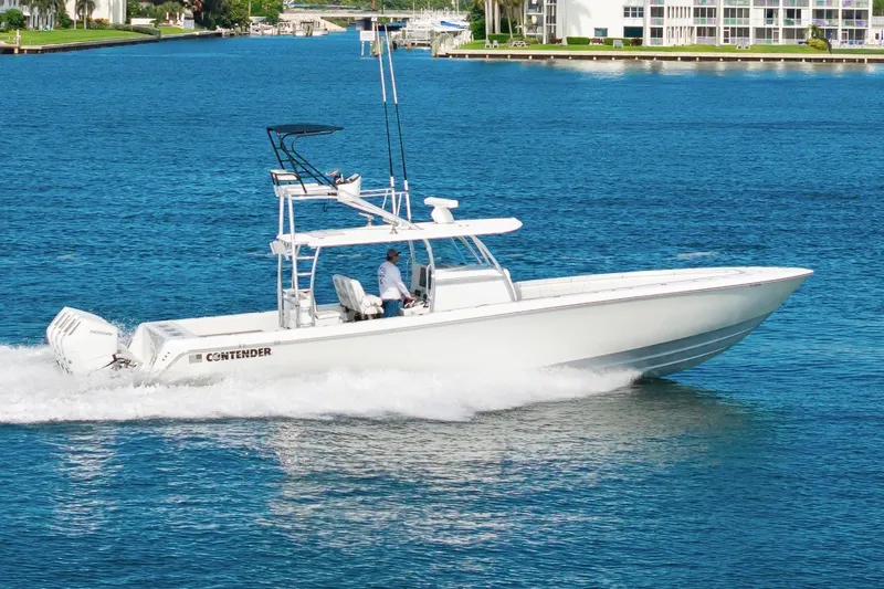 Slide: The Image of 2026 Contender 44 ST boat cruising on blue water near waterfront buildings. - 3
