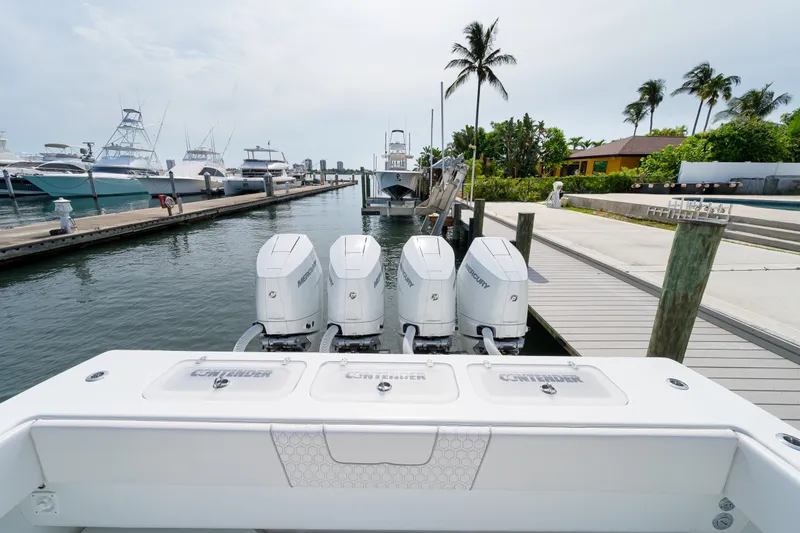 Slide: The Image of 2026 Contender 44 ST boat with four Mercury outboard engines docked at marina. - 22