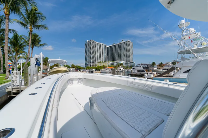 Slide: The Image of 2026 Contender 44 ST boat docked in marina with palm trees and high-rise buildings. - 19