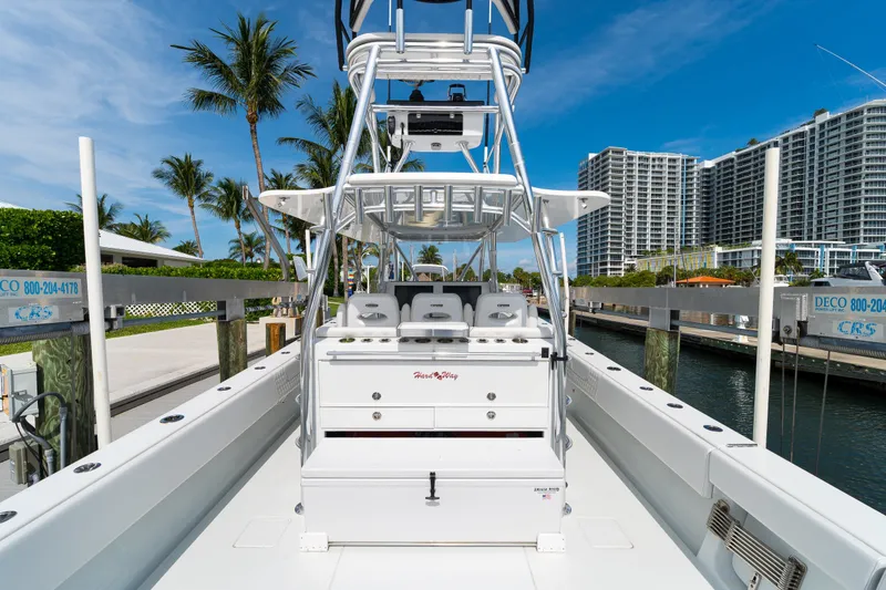 Slide: The Image of 2026 Contender 44 ST boat docked, featuring sleek design and modern amenities, with palm trees and buildings in the background. - 28