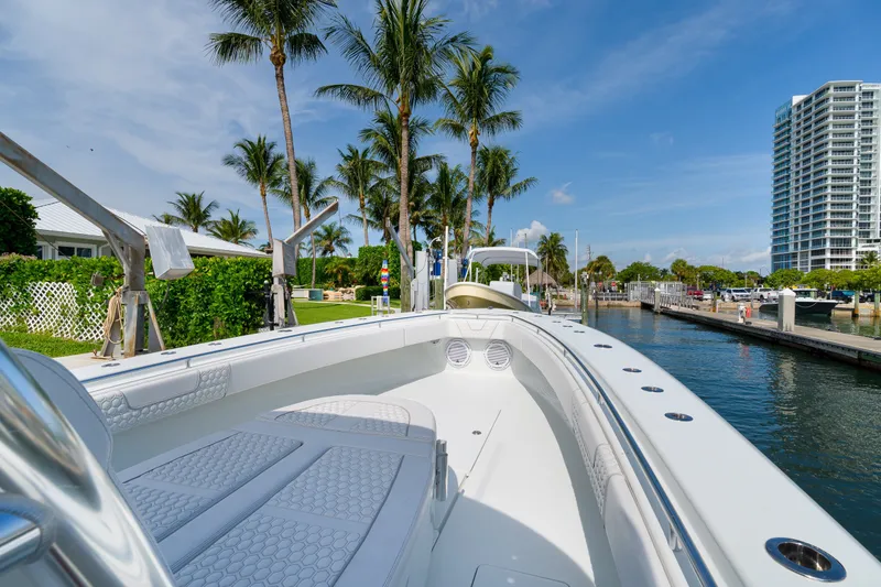 Slide: The Image of 2026 Contender 44 ST boat docked near palm trees and waterfront buildings. - 26