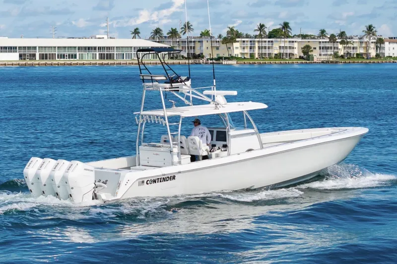 Slide: The Image of 2026 Contender 44 ST boat cruising on blue water near a coastal cityscape. - 13