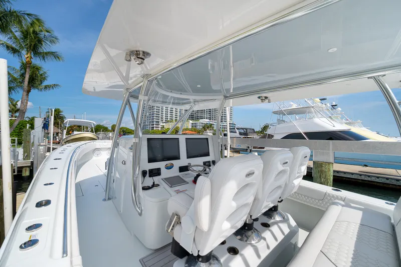 Slide: The Image of 2026 Contender 44 ST boat interior with helm, seats, and marina view. - 15