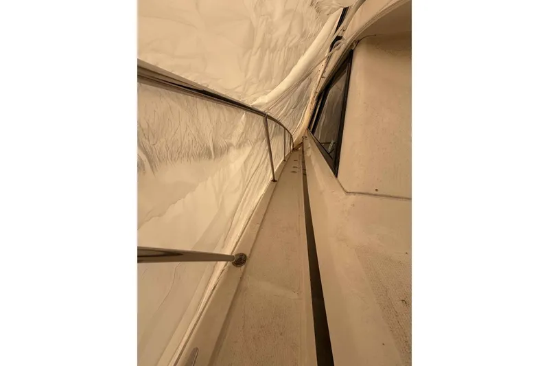 Slide: The Image of Side deck view of a 2000 Riviera 48 Convertible yacht under cover. - 4
