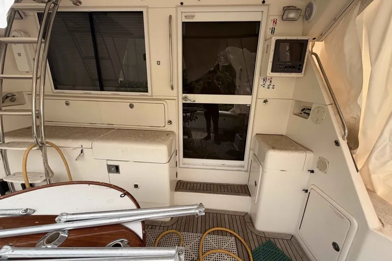 Slide: The Image of Interior view of a 2000 Riviera 48 Convertible yacht, featuring seating and control panel. - 5