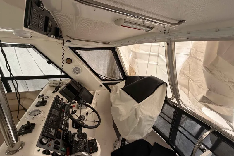Slide: The Image of Cockpit of 2000 Riviera 48 Convertible yacht with navigation controls and covered seating. - 12