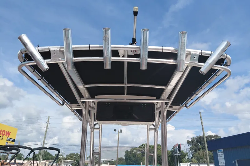 Slide: The Image of 2024 Key West 219 FS boat T-top with rod holders against blue sky. - 33