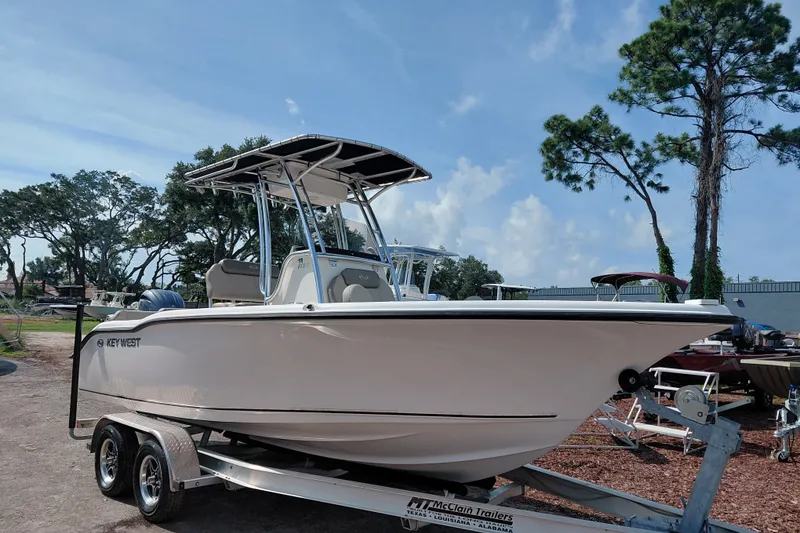 The Image of 2024 Key West 219 FS boat on trailer, parked outdoors under a clear sky. - 1