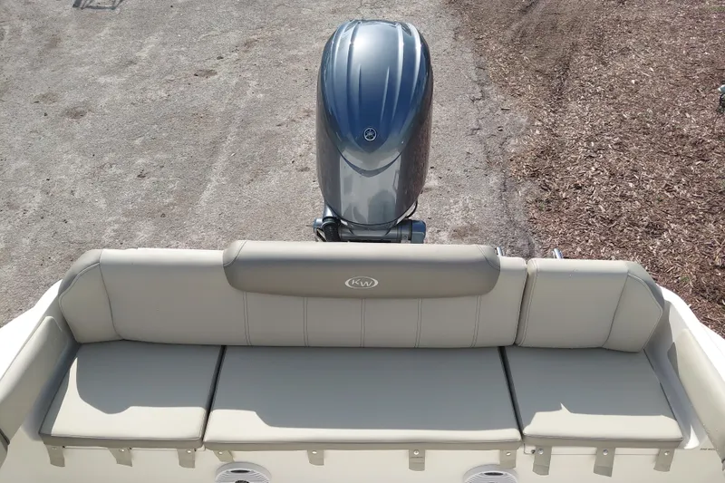Slide: The Image of 2024 Key West 219 FS boat with cushioned seating and outboard motor. - 28