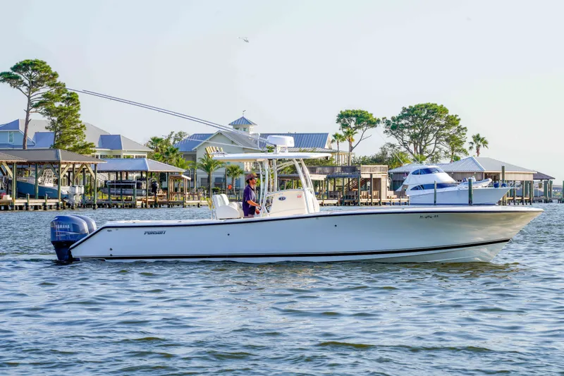 Slide: The Image of 2005 Pursuit 3480 Center Console boat cruising near waterfront homes. - 3