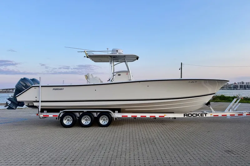 Slide: The Image of 2005 Pursuit 3480 Center Console boat on a trailer by the waterfront. - 1