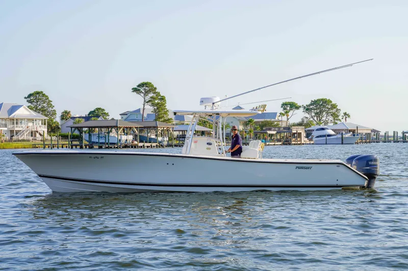 Slide: The Image of 2005 Pursuit 3480 Center Console boat on calm water near docks and houses. - 8