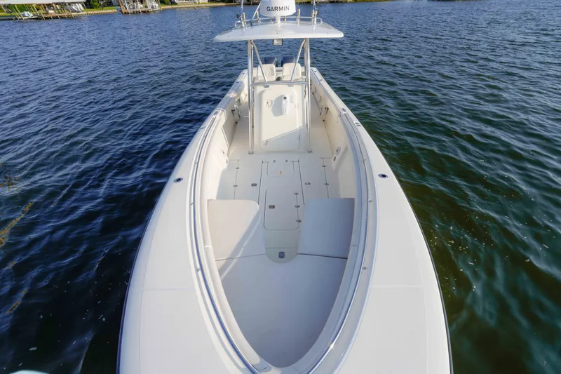 Slide: The Image of 2005 Pursuit 3480 Center Console boat on calm water, showcasing spacious deck and sleek design. - 34