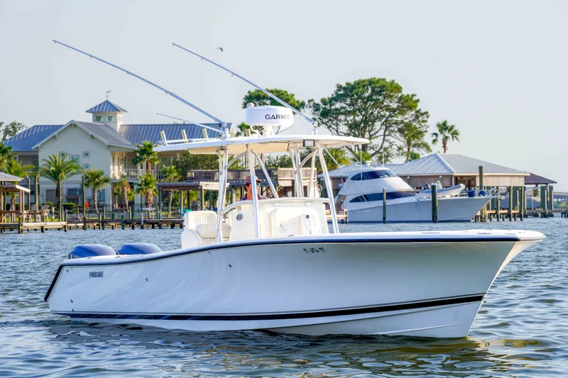 Slide: The Image of 2005 Pursuit 3480 Center Console boat on water near docks and palm trees. - 4