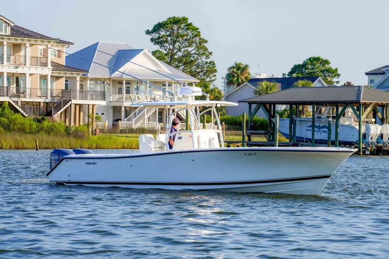 The Image of 2005 Pursuit 3480 Center Console boat cruising near waterfront homes. - 2