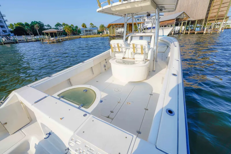 Slide: The Image of 2005 Pursuit 3480 Center Console boat on calm water near docks. - 21