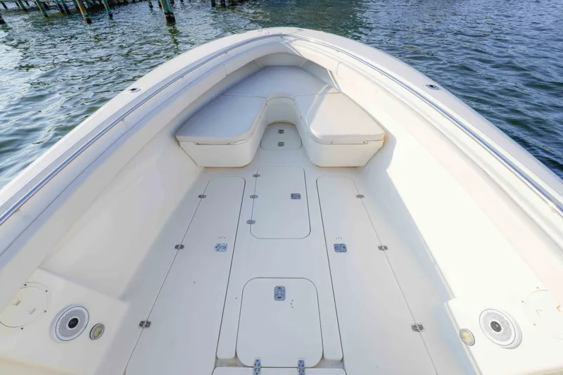 Slide: The Image of 2005 Pursuit 3480 Center Console boat deck with seating, on calm water. - 32