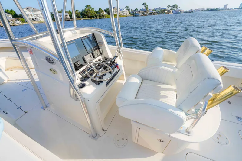 Slide: The Image of 2005 Pursuit 3480 Center Console boat interior with helm and seating, overlooking serene waters. - 25