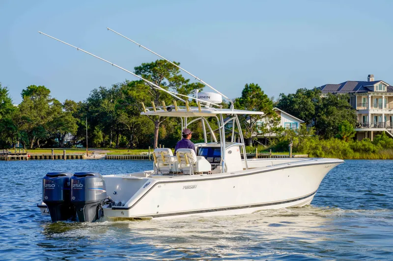 Slide: The Image of 2005 Pursuit 3480 Center Console boat cruising on a scenic waterway near waterfront homes. - 15
