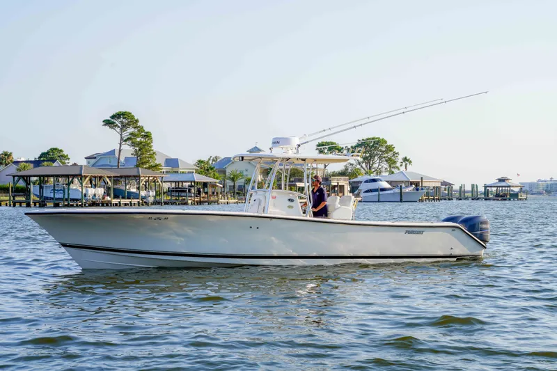 Slide: The Image of 2005 Pursuit 3480 Center Console boat cruising on a calm waterfront with docks in the background. - 7