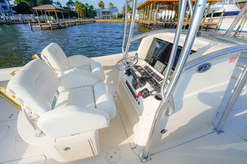 Slide: The Image of 2005 Pursuit 3480 Center Console boat interior with helm and white seating. - 26