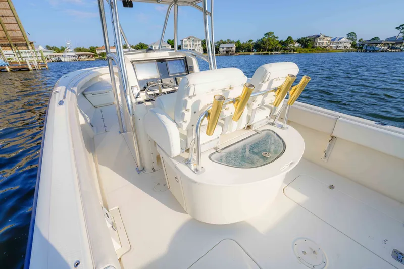 Slide: The Image of 2005 Pursuit 3480 Center Console boat with fishing rod holders on a sunny day. - 24