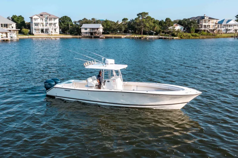 Slide: The Image of 2005 Pursuit 3480 Center Console boat on calm water near waterfront homes. - 45