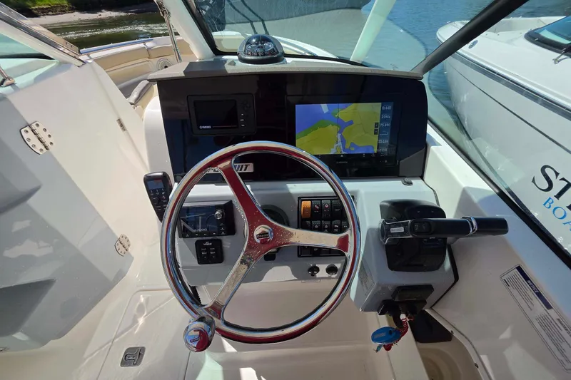 Slide: The Image of 2021 Pursuit DC 266 Dual Console helm with navigation display and steering wheel. - 18