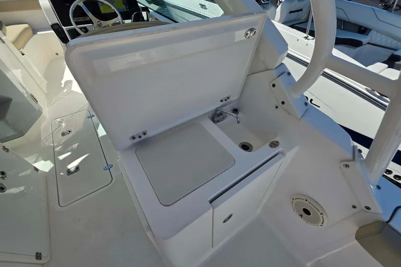 Slide: The Image of 2021 Pursuit DC 266 Dual Console boat interior with sink and storage area. - 13
