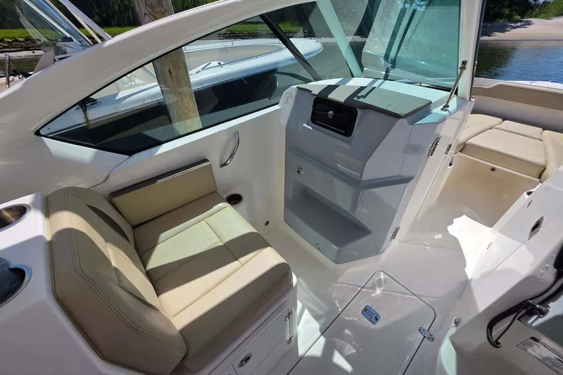 Slide: The Image of 2021 Pursuit DC 266 Dual Console boat interior with beige seating and sleek design. - 16