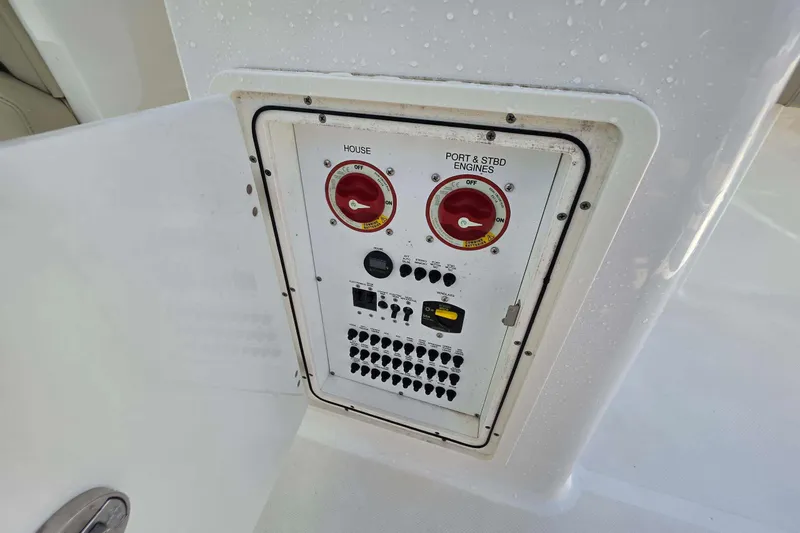 Slide: The Image of Control panel on 2021 Pursuit DC 266 Dual Console boat, featuring switches and dials. - 14