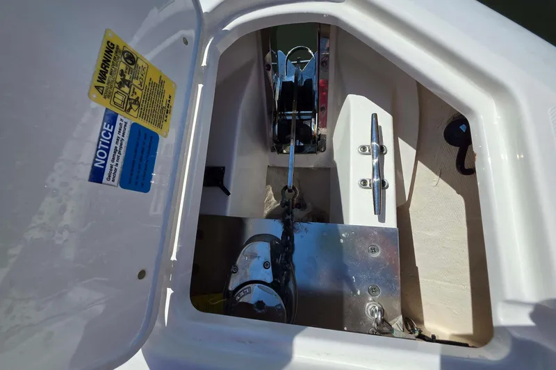Slide: The Image of Anchor compartment of 2021 Pursuit DC 266 Dual Console boat, featuring chain and cleat. - 24