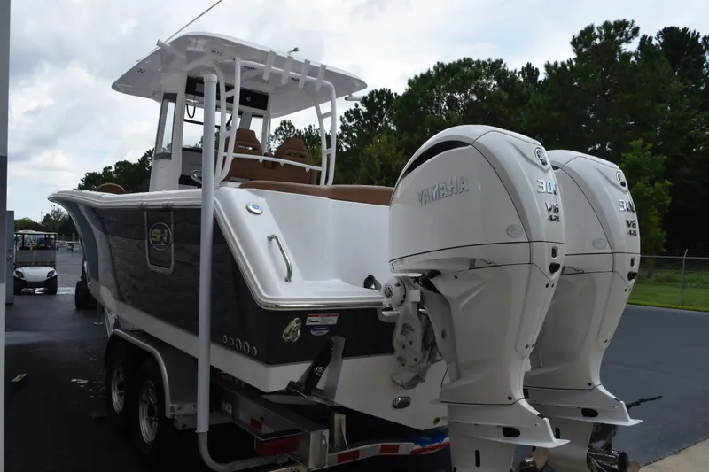 Slide: The Image of 2027 Sea Hunt Ultra 285SE boat with dual Yamaha engines on a trailer. - 6