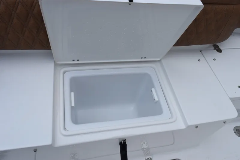 Slide: The Image of Open storage compartment on 2027 Sea Hunt Ultra 285SE boat, featuring white interior and brown seating. - 24
