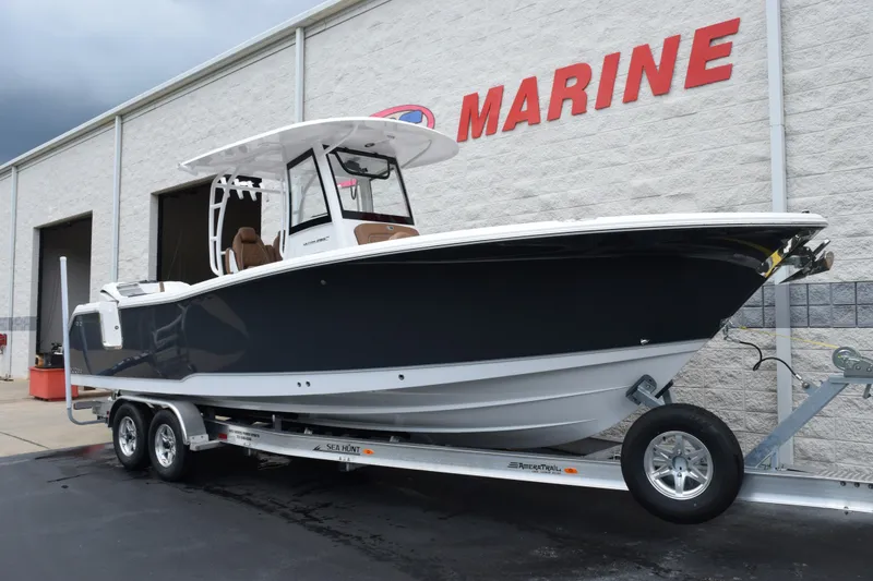 Slide: The Image of 2027 Sea Hunt Ultra 285SE boat on trailer outside marine dealership. - 2