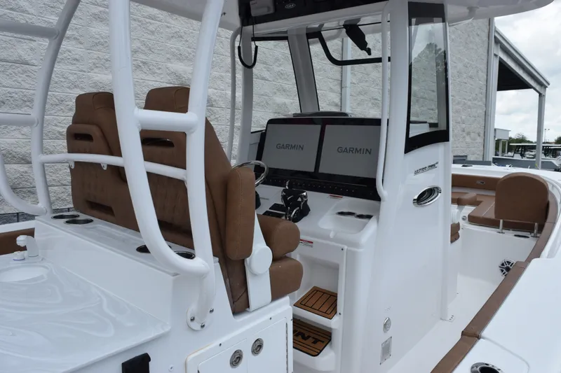 Slide: The Image of 2027 Sea Hunt Ultra 285SE boat interior with Garmin navigation displays and brown seating. - 8