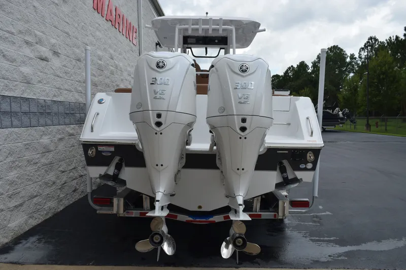 Slide: The Image of 2027 Sea Hunt Ultra 285SE boat with dual Yamaha 300 V6 engines, parked outdoors. - 5