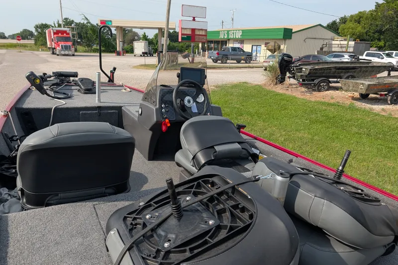 Slide: The Image of 2021 Tracker Bass Tracker Classic XL boat interior with seats and steering wheel, parked near a store. - 62