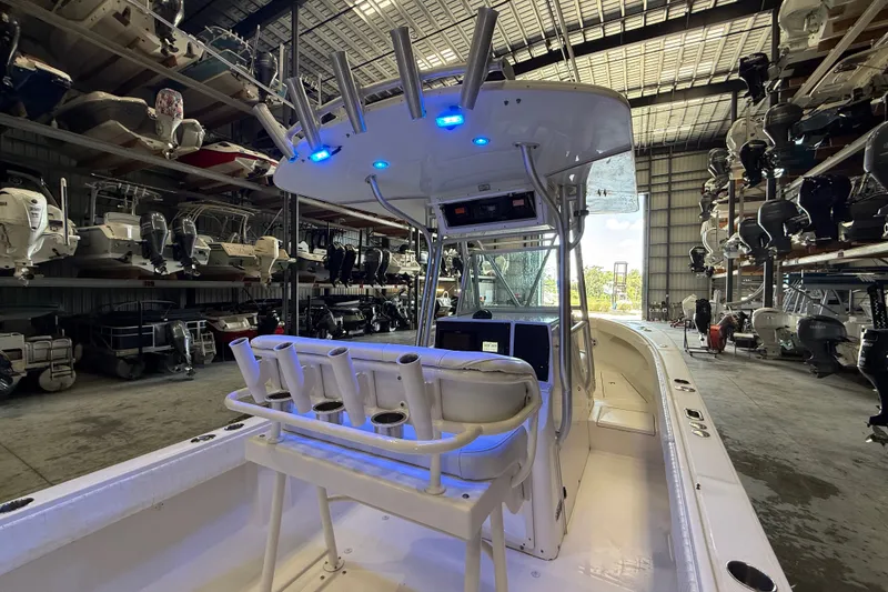 Slide: The Image of 2007 Regulator 26 Classic boat in storage, featuring rod holders and illuminated console. - 20