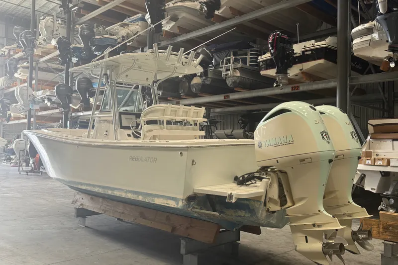 Slide: The Image of 2007 Regulator 26 Classic boat with twin Yamaha engines in indoor storage. - 17