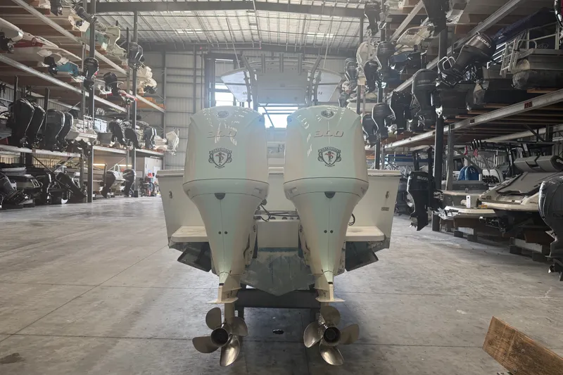 Slide: The Image of 2007 Regulator 26 Classic boat with twin engines in a spacious indoor storage facility. - 18