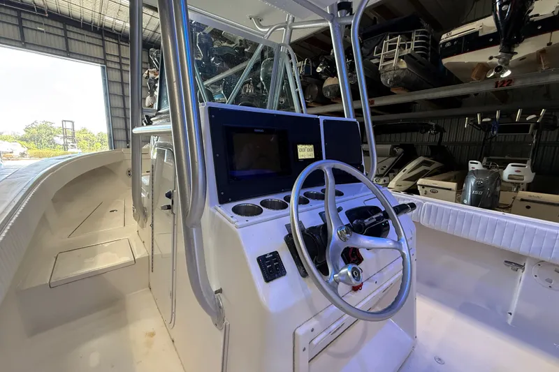 Slide: The Image of 2007 Regulator 26 Classic boat interior with steering wheel and control panel in a storage facility. - 21