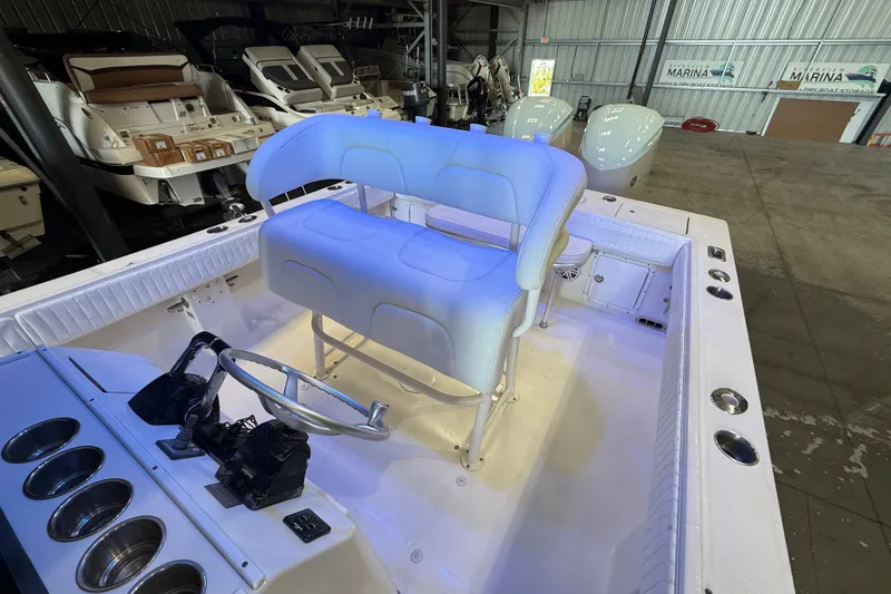 Slide: The Image of 2007 Regulator 26 Classic boat interior with helm seating and steering wheel in a marina. - 22