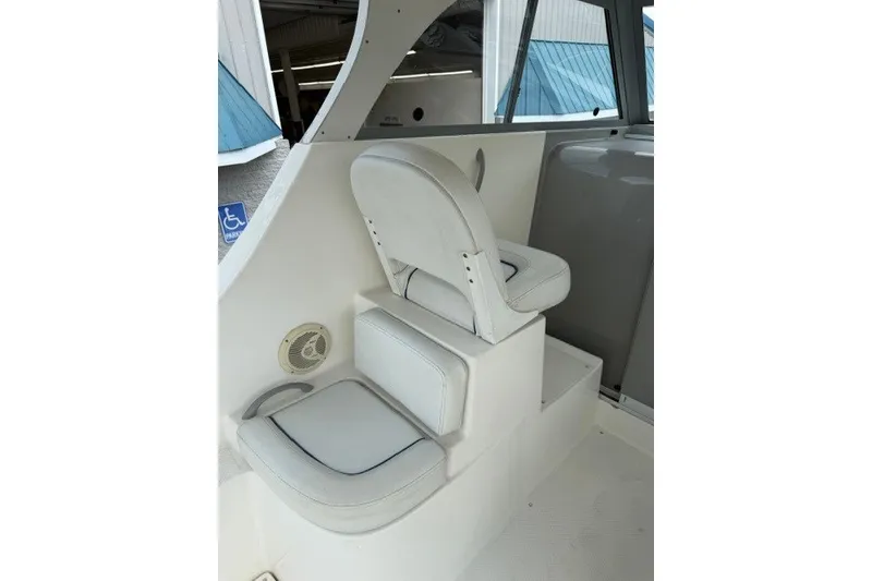 Slide: The Image of 2007 Bayliner Discovery 246 interior seating with white upholstery and step access. - 12