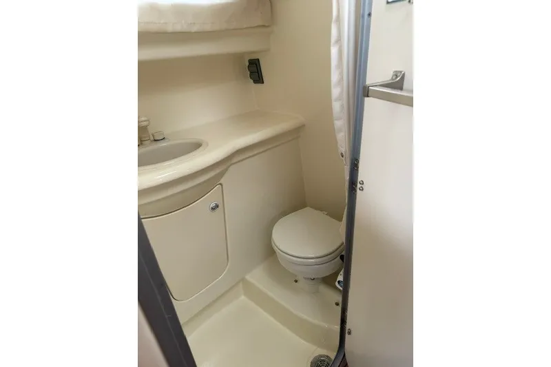 Slide: The Image of Compact bathroom in 2007 Bayliner Discovery 246 boat, featuring toilet and sink. - 4