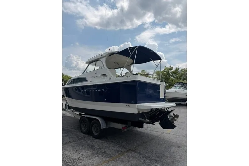 Slide: The Image of 2007 Bayliner Discovery 246 boat on trailer under cloudy sky. - 16