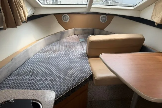 Slide: The Image of 2007 Bayliner Discovery 246 interior with seating, table, and sleeping area. - 5