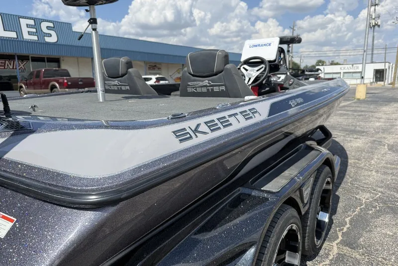 Slide: The Image of 2018 Skeeter FX21 boat with sleek design, parked outdoors under a cloudy sky. - 6