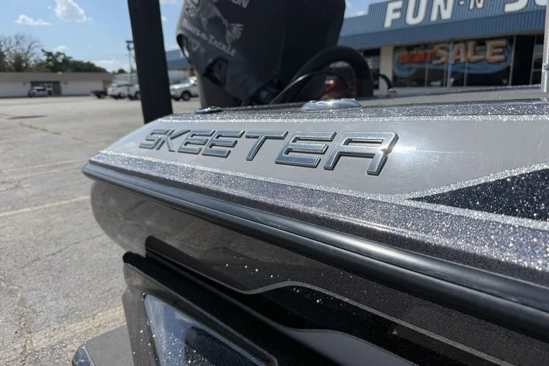 Slide: The Image of 2018 Skeeter FX21 boat close-up with metallic finish in dealership lot. - 16