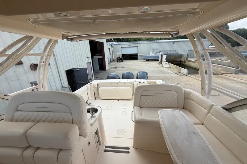 Slide: The Image of 2017 Grady-White Freedom 335 boat interior with seating and table, docked at a marina. - 11